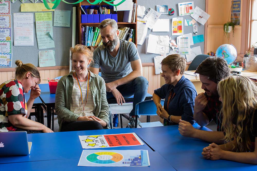 A group of educators at a table, laughing