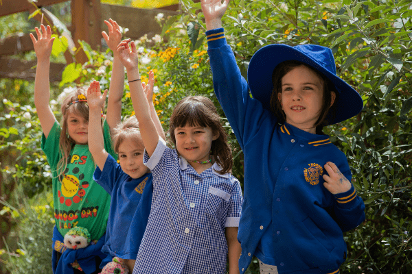 Four children raising their hands to ask a question