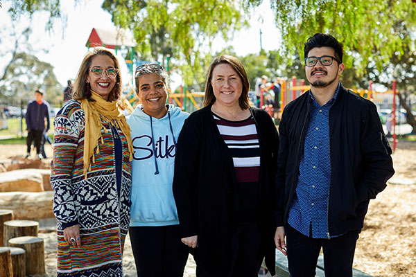 A group of educators standing outside, smiling at the camera