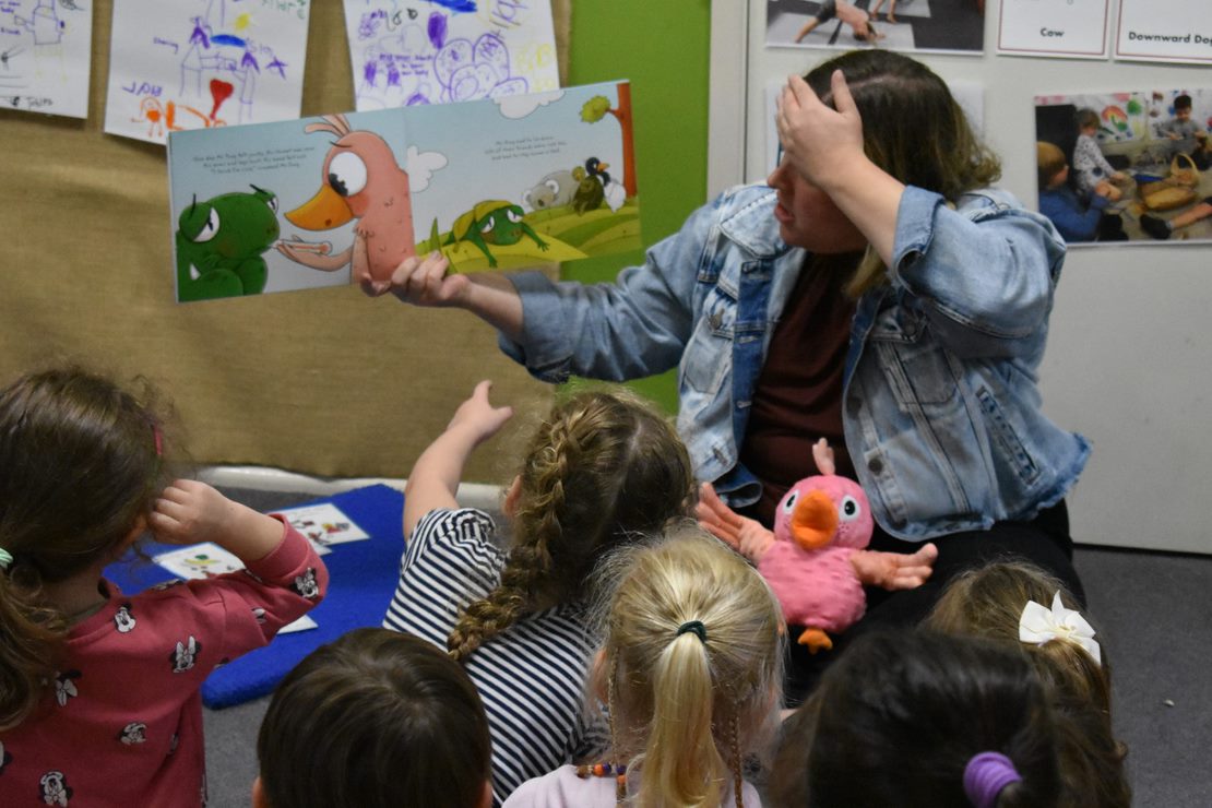 Educator reads a book to children 