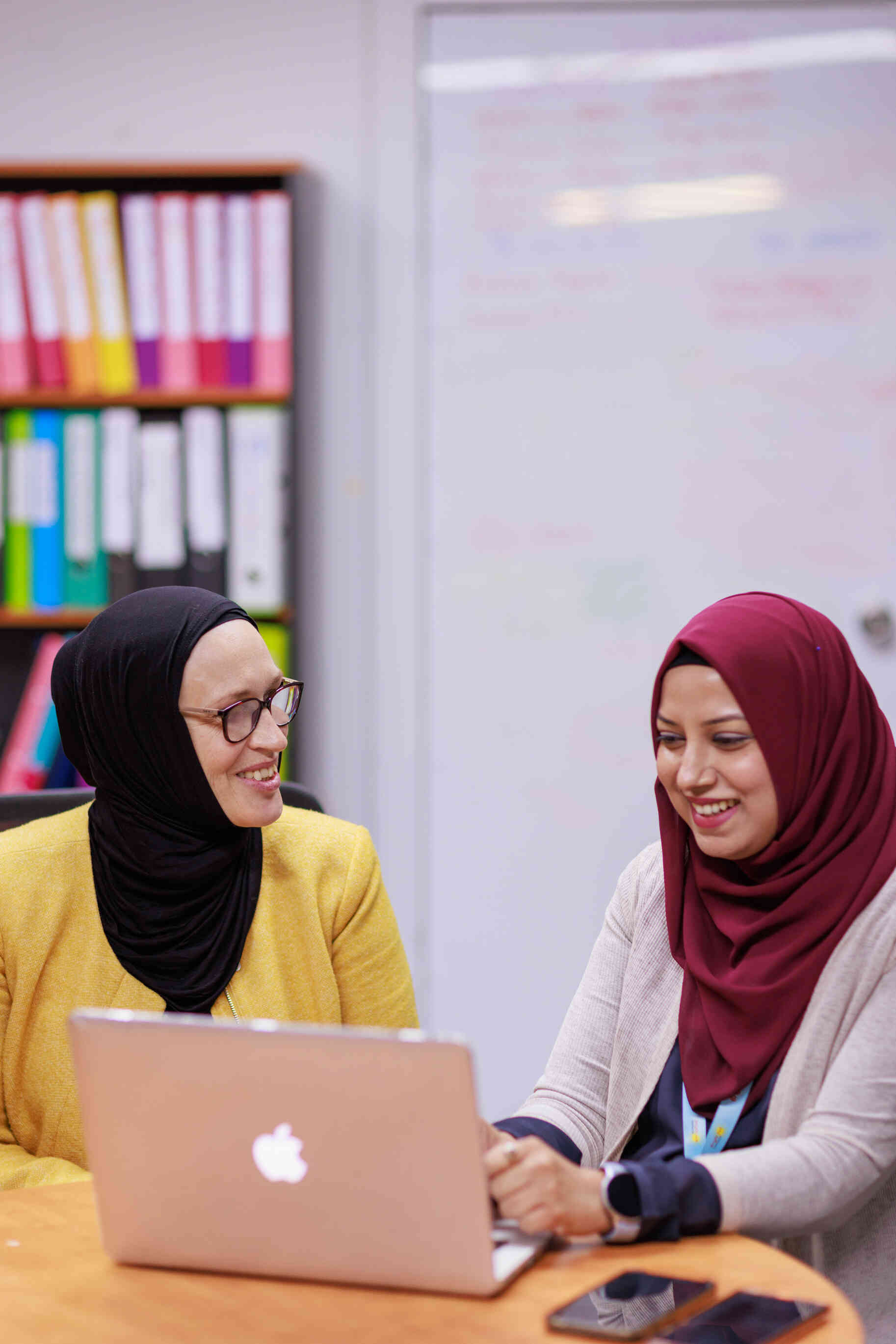 Two educators talk around a table