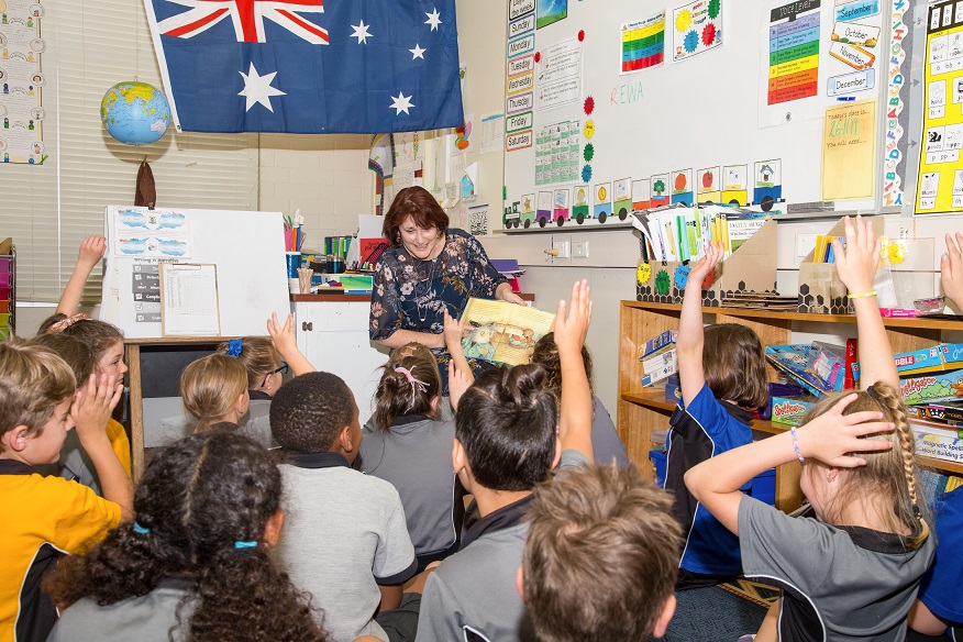 An educator reading to a busy class of children