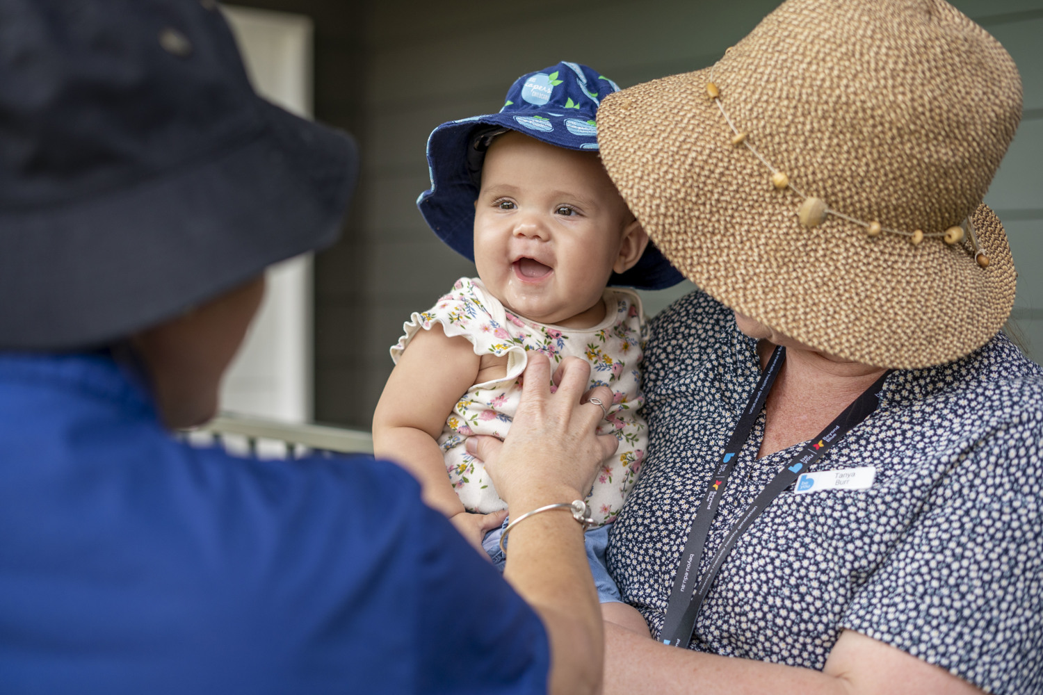 An adult, holding a smiling baby