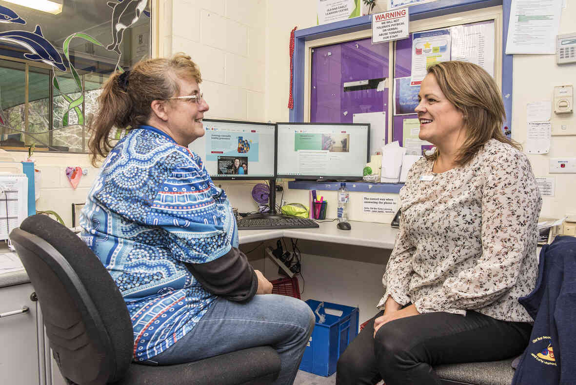 Two adults in an office, engaged in conversation