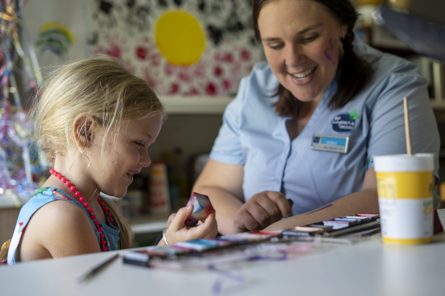 An educator and young child, doing art together