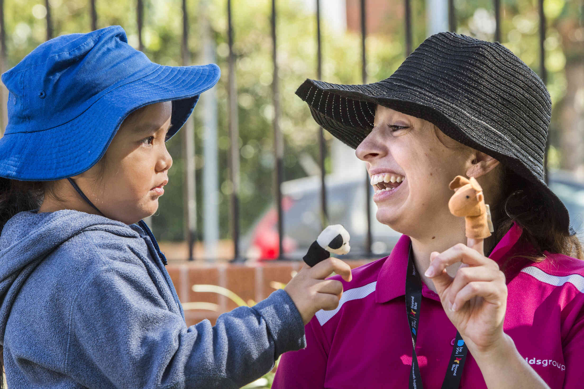 An educator and a young child, laughing 