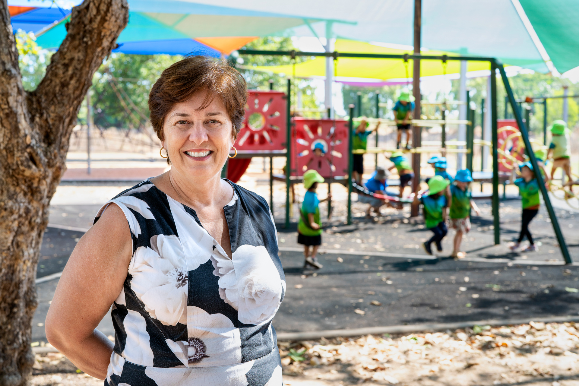 An adult in a playground, smiling at the camera