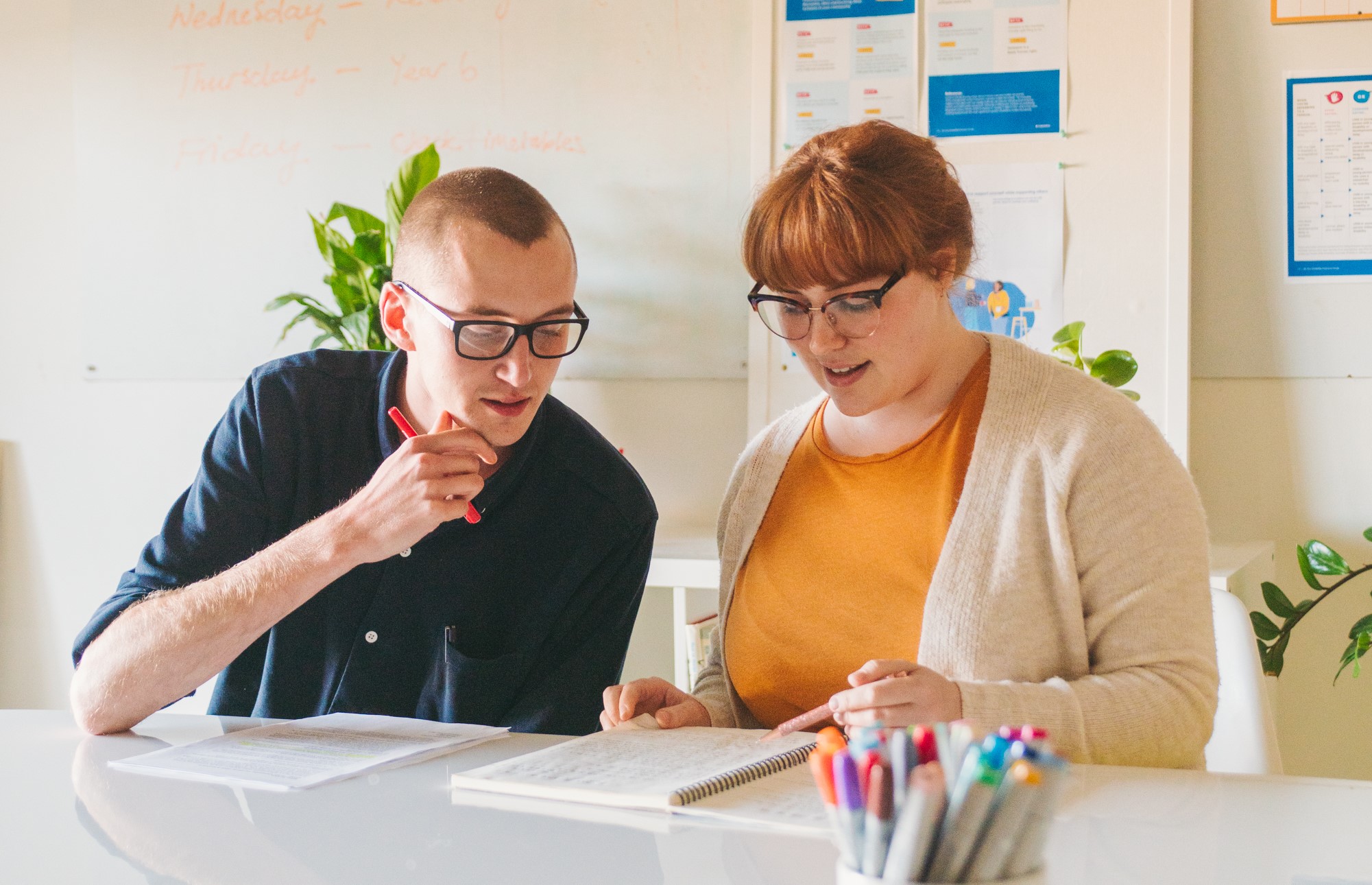 Two adults working together at a desk