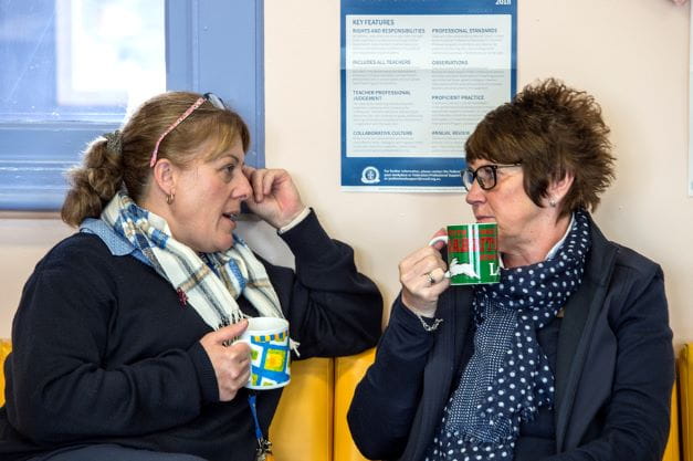 Two adults having a conversation while drinking tea