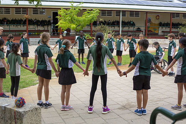 A group of children holding hands in a large circle