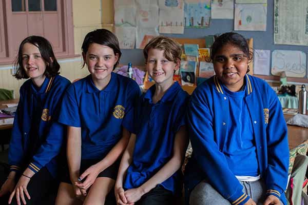 A group of children, smiling at the camera 