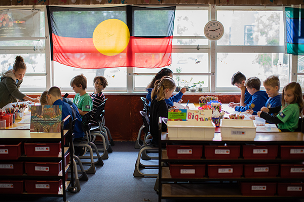 A classroom with young children, with the Australian Aboriginal flag hanging in the window
