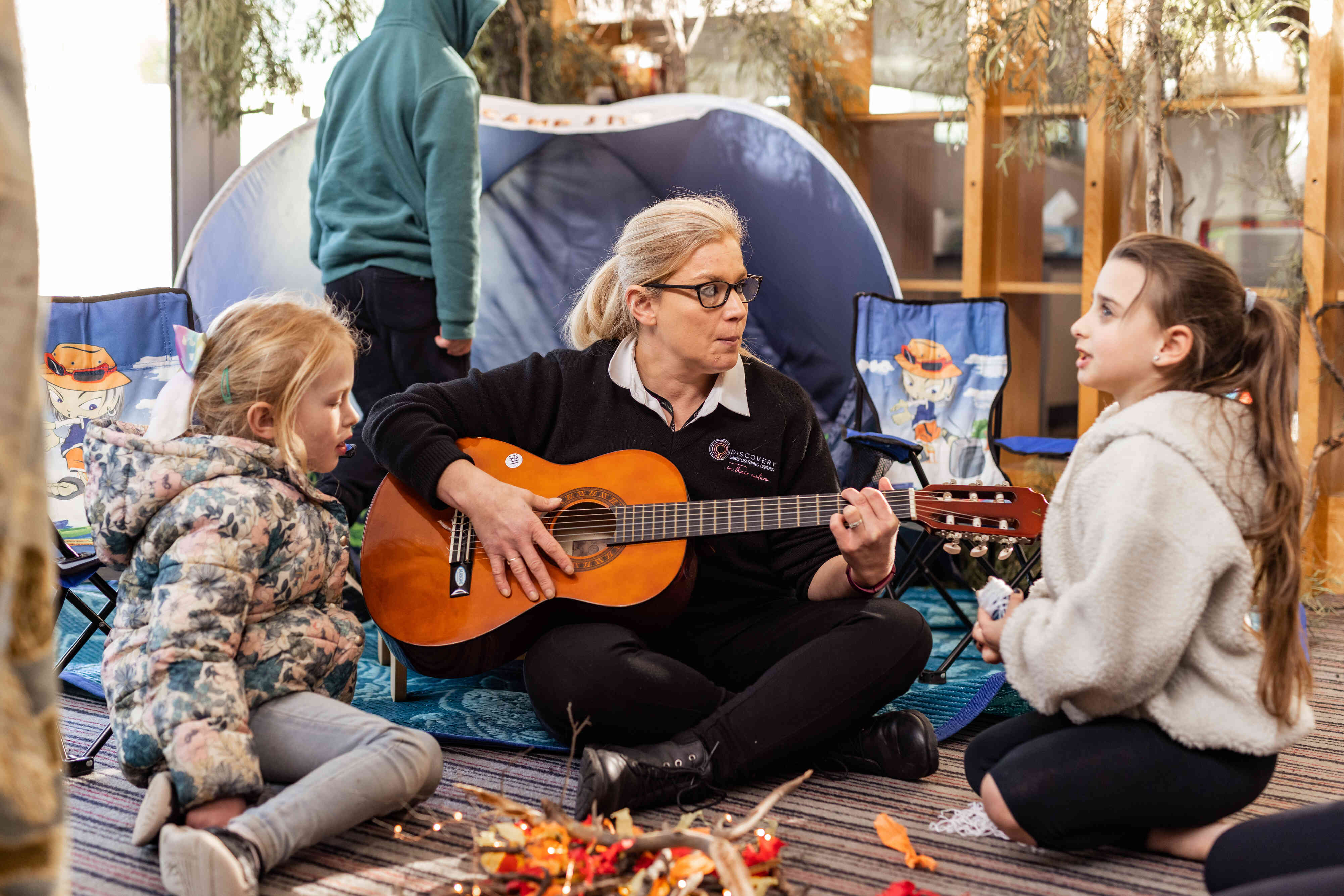 Educator plays guitar with children