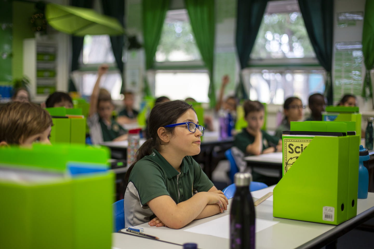 A classroom of children looking towards an educator