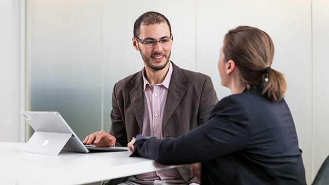 Two educators at a table, engaged in conversation